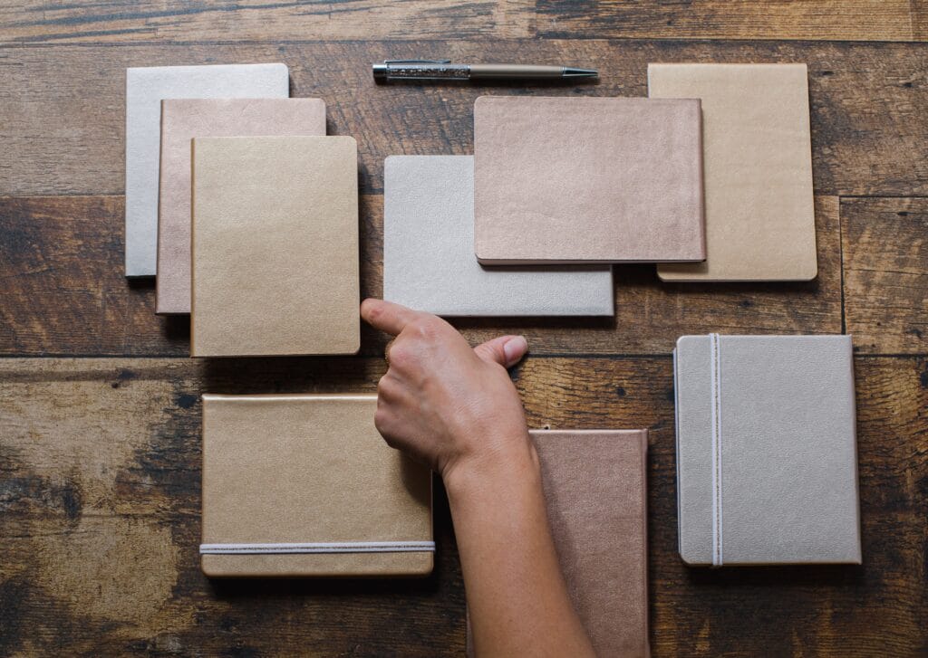 flatlay-of-notebooks-pens-and-a-persons-hand