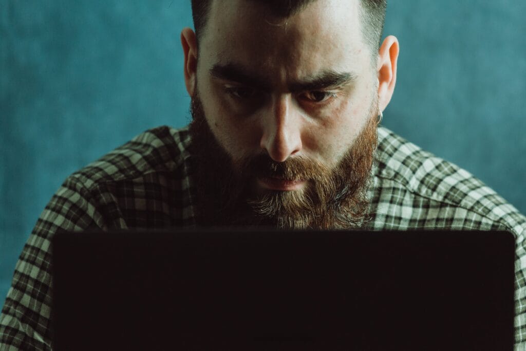 man-in-deep-concentration-looks-down-at-a-laptop